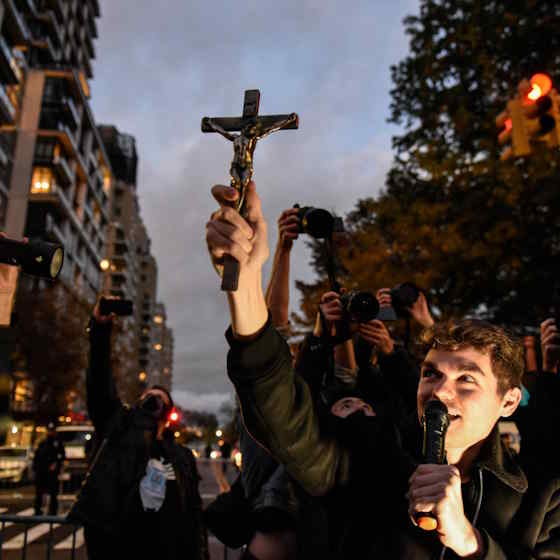 Nick Fuentes holding a crucifix.jpeg